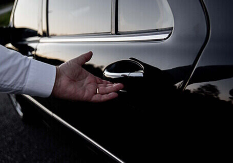 Limousine hire service Person opening back door of a corporate limousine